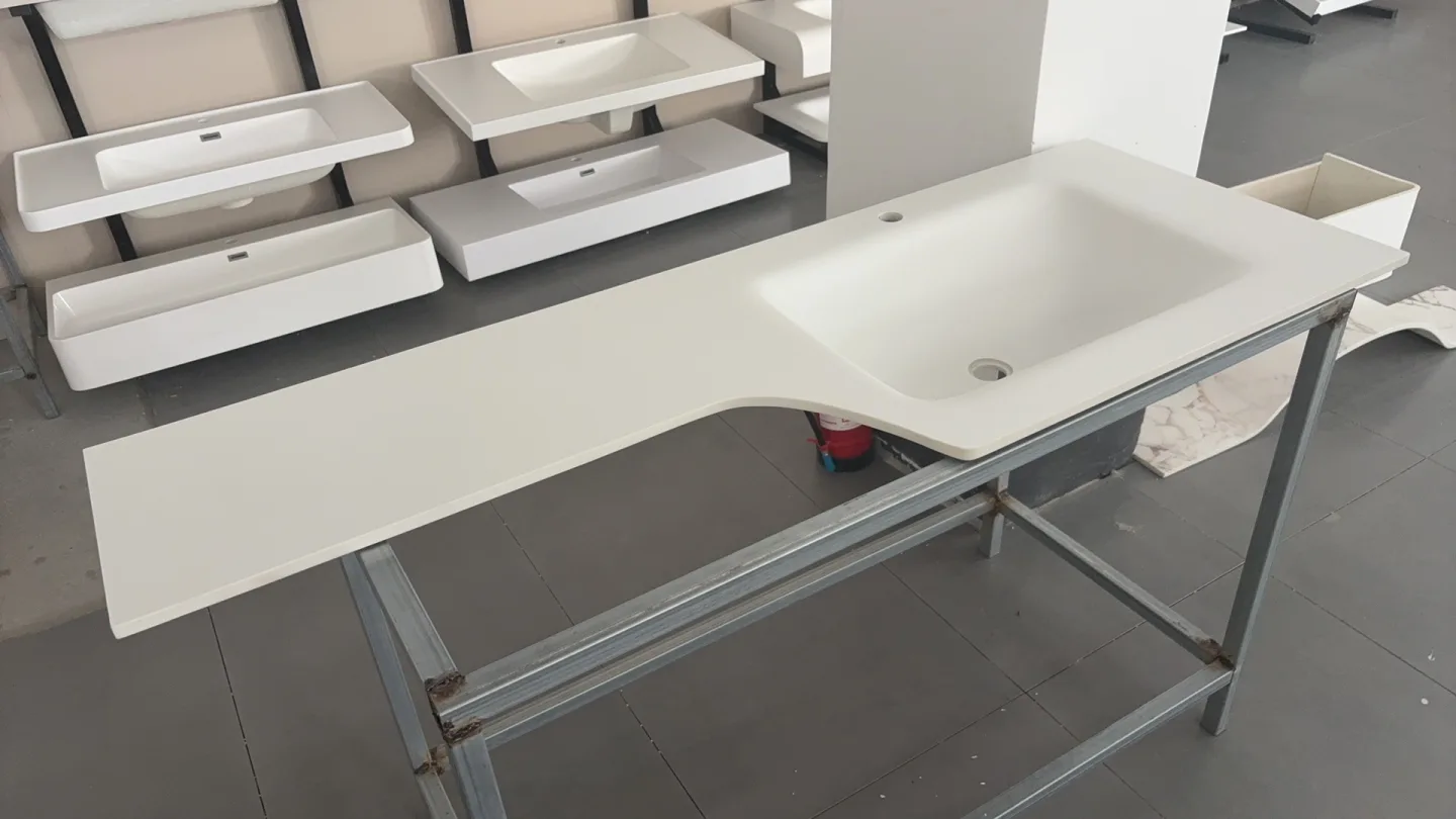 Shaped white basin top and several rectangular basins on workshop racks